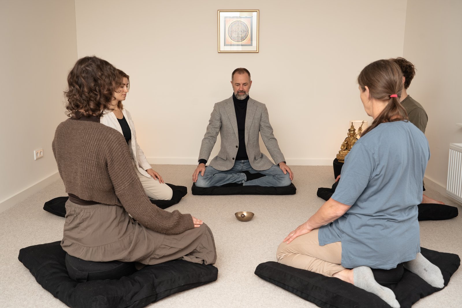 Meditatiegroep zit samen in een kring in een lichte ruimte
